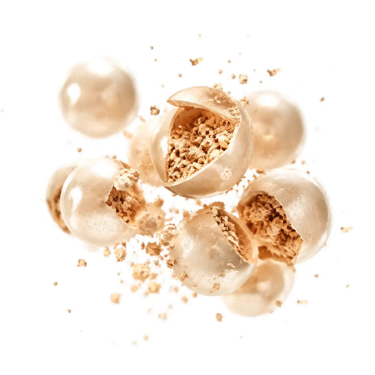 Cosmetic capsules opening to reveal warm beige pigment